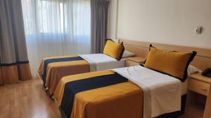 Habitación de hotel con 2 camas y ventana en Callao Suites Recoleta en Buenos Aires