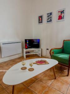 a living room with a white coffee table and a tv at Cozy - Centre Historique - Gare à proximité - Grande Terrasse in Béziers