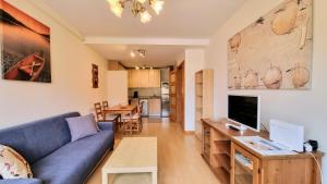 a living room with a blue couch and a tv at Aprtamento El Llagu Zolitru in Llanes