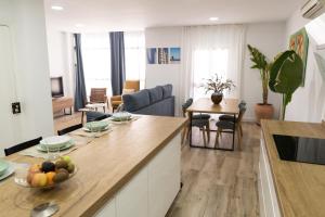 a kitchen and living room with a table with a bowl of fruit at Calvario 53 by 7Escalones in Rota