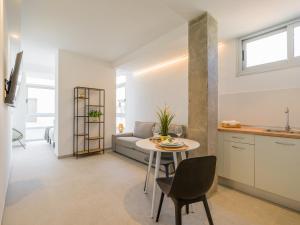 a kitchen and living room with a table and a couch at Shabolo Apartments Las Palmas in Las Palmas de Gran Canaria +60 photos