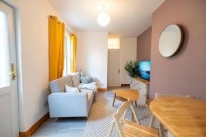 een woonkamer met een witte bank en een tafel bij Cozy & Stylish 2bed Flat - WiFi - Parking - Garden - Bristl in Bristol
