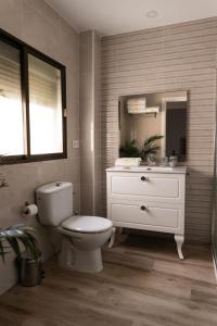 bagno con servizi igienici, lavandino e specchio di Calvario 53 by 7Escalones a Rota