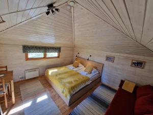 1 dormitorio con 1 cama en una habitación de madera en Reindeer Lodge, en Jukkasjärvi