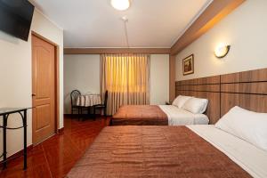 Habitación de hotel con 2 camas y mesa en Hotel Bohemia en Lima