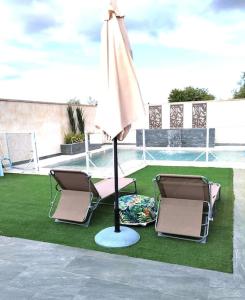 two chairs and an umbrella next to a pool at Vivienda familiar cerca de Toledo y de Puy Du Fou in Burguillos de Toledo