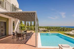 a patio with a table and chairs next to a swimming pool at Villa Eva Skala in Skala Kefalonias