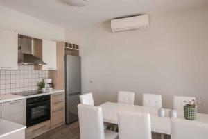 a kitchen with a white table and white chairs at Villa Eva Skala in Skala Kefalonias
