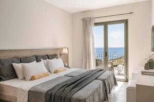 a bedroom with a large bed with a view of the ocean at Villa Eva Skala in Skala Kefalonias +34 photos