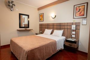 a hotel room with a large bed and a fan at Hotel Bohemia in Lima