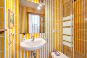 a yellow bathroom with a sink and a toilet at Can Marineta in Palma de Mallorca +17 photos