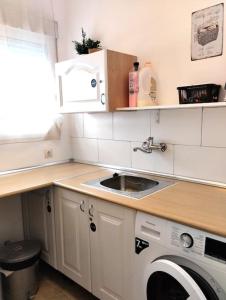 a kitchen with a sink and a washing machine at Vivienda familiar cerca de Toledo y de Puy Du Fou in Burguillos de Toledo