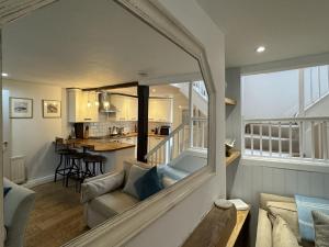 a living room with a couch and a kitchen at Rose Cottage - Central Dartmouth in Dartmouth
