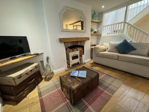 a living room with a couch and a fireplace at Rose Cottage - Central Dartmouth in Dartmouth