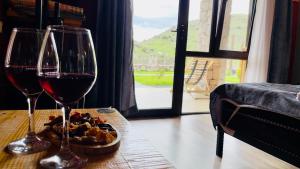 T'mogviにあるHotel Hobbiton near Vardzia Cavesのワイン2杯、テーブルの上に食べ物1杯
