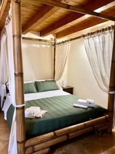 1 dormitorio con cama con dosel y sábanas verdes en B&B Antico Caricatore - Ex B&B Porta di Mare en Sciacca