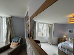 a bedroom with a mirror and a bed and a window at Rose Cottage - Central Dartmouth in Dartmouth