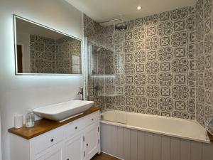 a bathroom with a sink and a tub and a mirror at Rose Cottage - Central Dartmouth in Dartmouth +14 photos