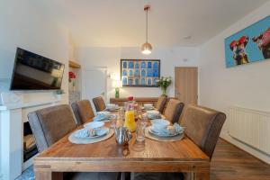 a dining room with a wooden table and chairs at Kirkmoor Cottage - Cosy home central Clitheroe in Clitheroe