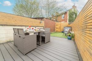 a patio with a table and chairs on a deck at Kirkmoor Cottage - Cosy home central Clitheroe in Clitheroe