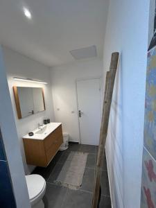 a bathroom with a white toilet and a sink at Bungalow proche de la plage de l'anse à l'eau in Saint-François