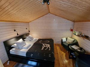 a bedroom with a bed and a chair in a room at Reindeer Lodge in Jukkasjärvi