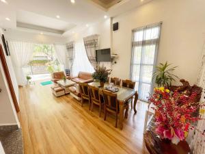 ein Wohnzimmer mit einem Tisch und einem Esszimmer in der Unterkunft Trung Nghĩa Villa 20 in Da Lat