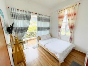 Schlafzimmer mit einem Bett und einem Fenster in der Unterkunft Trung Nghĩa Villa 20 in Da Lat