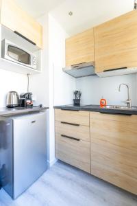 eine Küche mit Holzschränken und einer Spüle in der Unterkunft Studio centre Cannes in Cannes + 2 Fotos