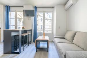 ein Wohnzimmer mit Sofa und Tisch in der Unterkunft Studio centre Cannes in Cannes