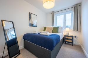 1 dormitorio con cama y espejo en Ariel Wharf by Tŷ SA, en Newport