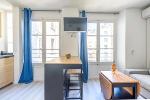 ein Wohnzimmer mit einer Küche mit blauen Vorhängen in der Unterkunft Studio centre Cannes in Cannes