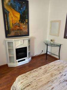 un salon avec une télévision au-dessus d'une cheminée dans l'établissement Villa de charme à Martignargues avec piscine privée, à Martignargues