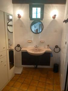 une salle de bain avec un lavabo et un miroir dans l'établissement Villa de charme à Martignargues avec piscine privée, à Martignargues