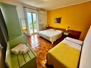 a hotel room with two beds and a balcony at Hotel Silvana Garn&igrave; in Limone sul Garda