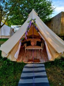 une tente en toile avec un lit dans l'établissement French Tent secret garden glamping, à Newark-on-Trent