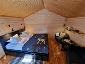 Reindeer Lodge في يوكاسيارفيه: غرفة نوم بسرير وكرسي في غرفة