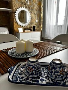 a table with two blue and white plates and candles at Brezza Marina Ortigia in Siracusa