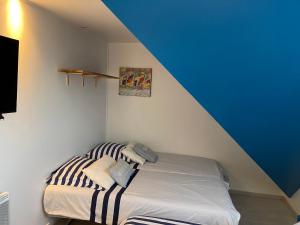 Bett in einem Zimmer mit blauer Decke in der Unterkunft La Villa KEROMER in Étel