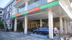 日惹的住宿－Hotel Wijaya Family，停在大楼前的汽车