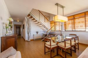 a dining room with a glass table and a staircase at Caís in São Martinho do Porto