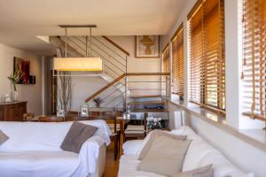 a living room with white furniture and a staircase at Caís in São Martinho do Porto +30 photos