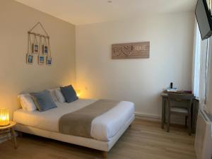 a bedroom with a bed and a desk and a bed sidx sidx sidx at LOGIS HOTELS - Hôtel et Restaurant L'Océana in Lanton