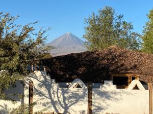 uma montanha na distância atrás de uma casa em Cabañas Voyage Atacama em San Pedro de Atacama