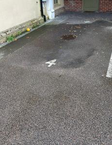 an empty parking lot with a white arrow on the street at Comfort Arena in Colchester