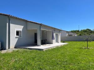 una casa con césped delante en Villa MaLou en Pradons