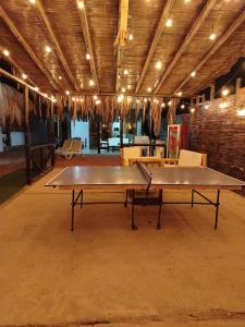 un tavolo da ping pong in una grande stanza con luci di puntacanoas bungalows a Canoas