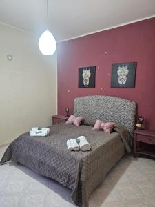 a bedroom with a large bed with two towels on it at A casa di Livia in Villabate