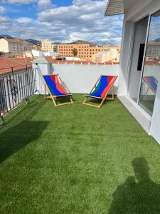 Duas cadeiras numa varanda com relva verde em The sunnydise Apartment LUXURY DUPLEX in the city center em Málaga