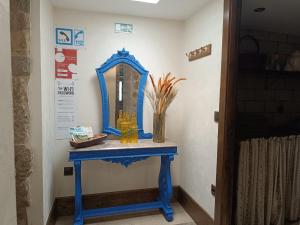 a blue table with a mirror on a wall at Casa da Benda in Estorãos